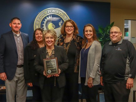 Sedgwick County Health Director Adrienne Byrne posing with five representatives of the Derby Collaborative.