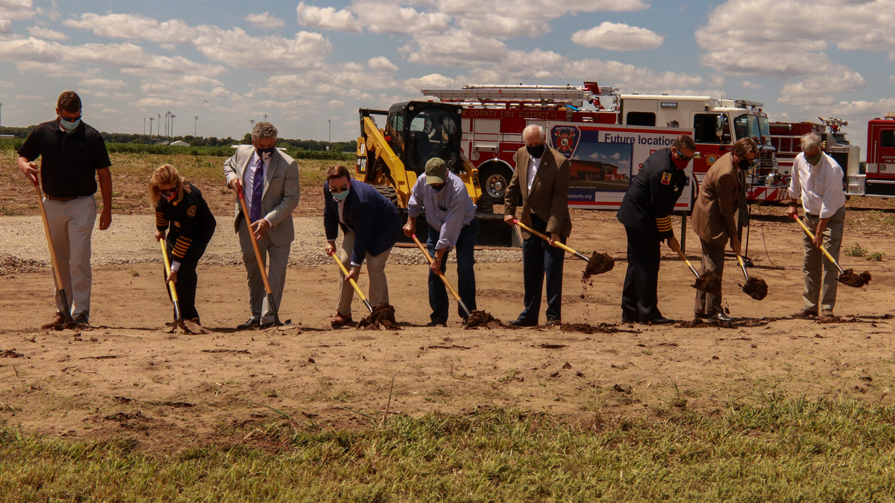 Group of nine officials breaking ground on new fire station.