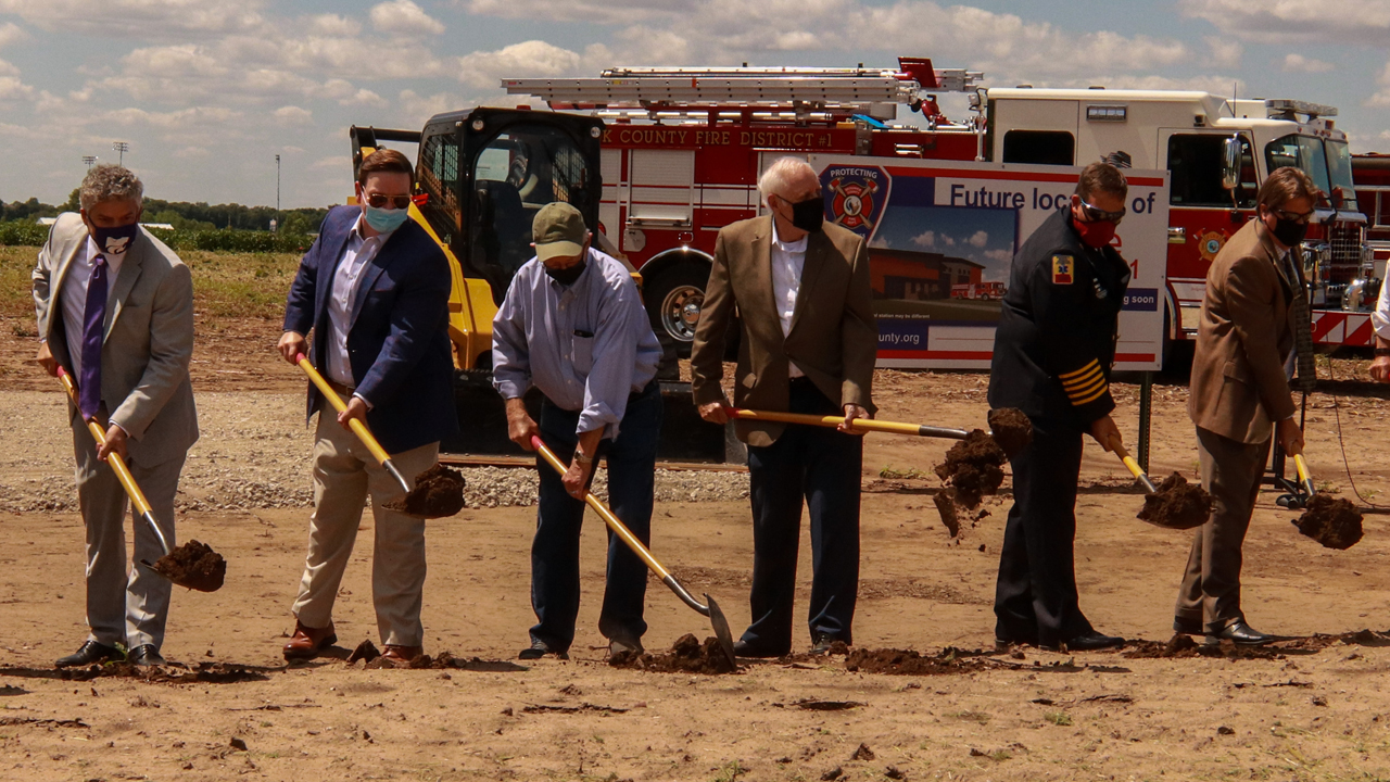 Photo of six officials breaking ground on new station site.